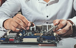 Technician working on a laptop board repair